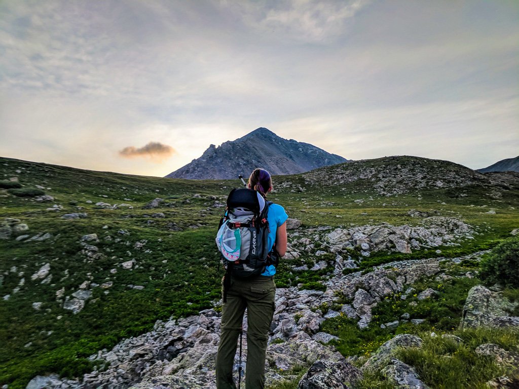 woman standing in front of a mountain for a guide to hiking guide to hiking