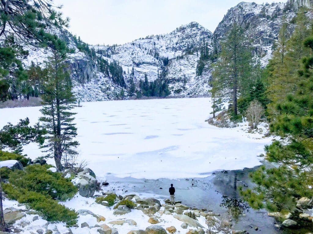 A view of a frozen Eagle Lake near lake tahoe with snowy mountains and an ice-covered lake