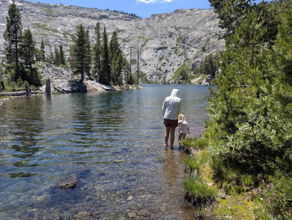 A woman and child standing in an alpine lake at Ralston Lake near Lake Tahoe