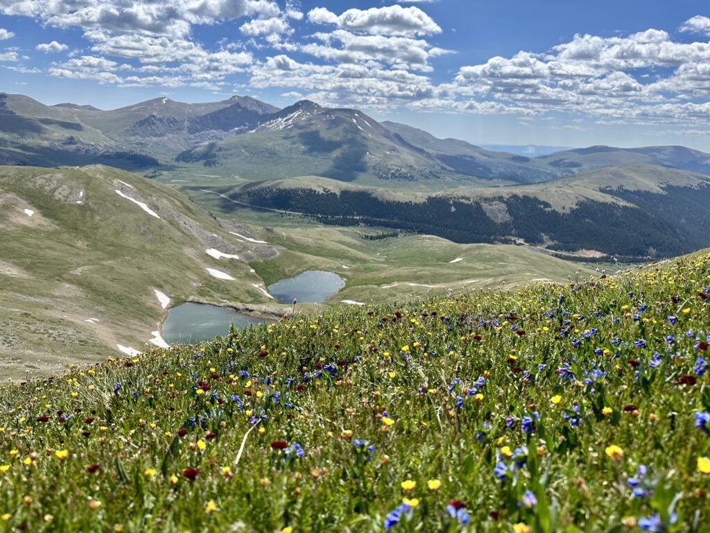 Square Top Mountain is a Colorado 13er that offers beautiful views of lush green hillsides and sparkling alpine lakes.