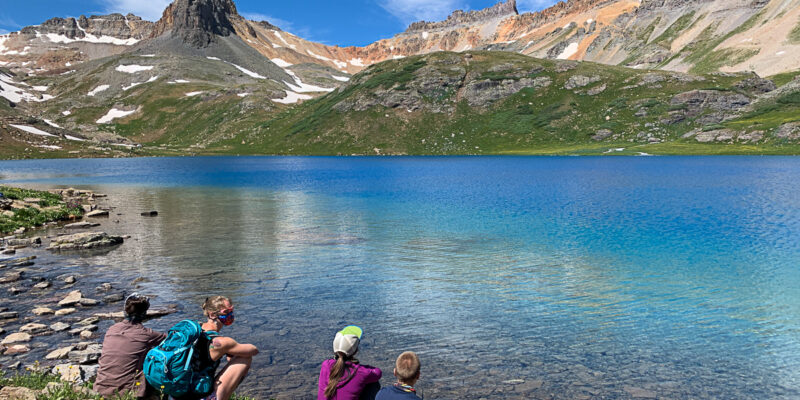 Hikers sitting by the lake in Telluride in the summer.