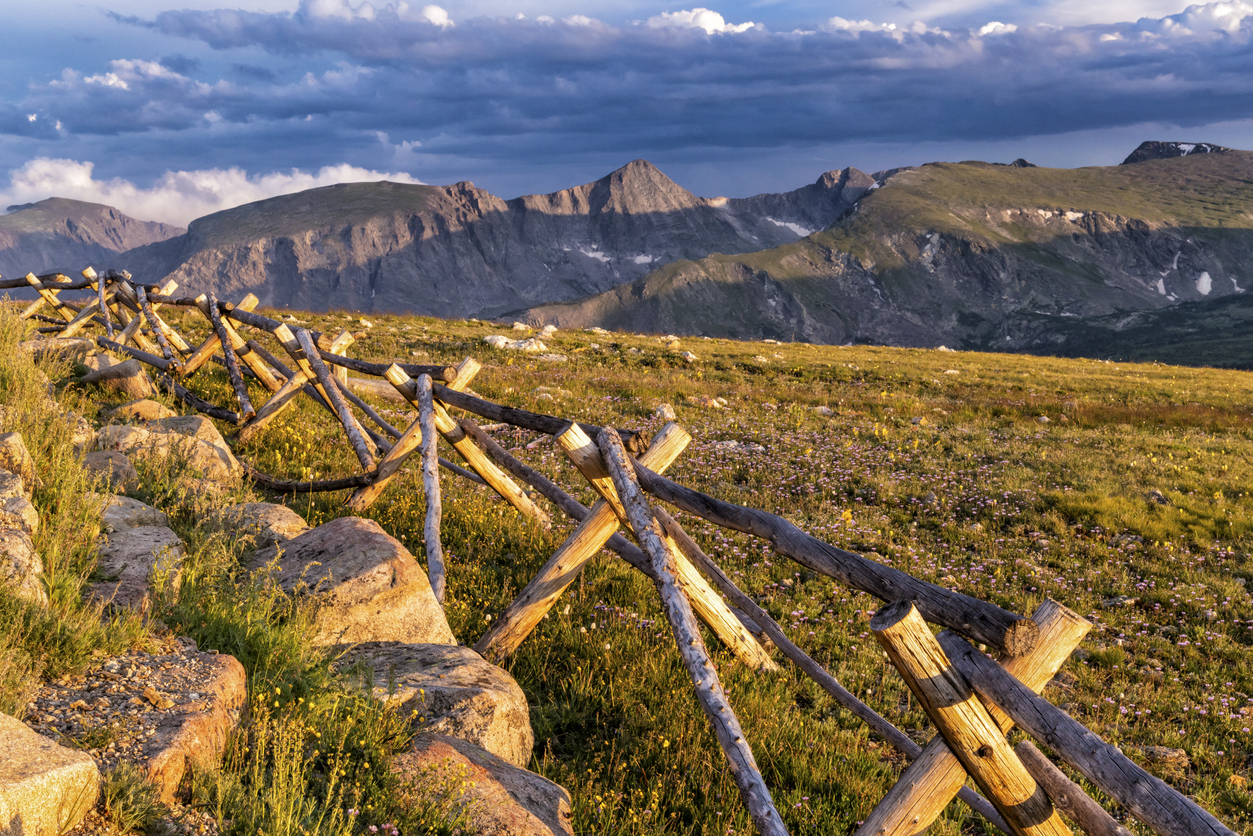 A wooden fence lit by the golden setting sun at the Gore Range Overlook on Trail Ridge Road, Rocky Mountain National Park, Colorado.. Beautiful scenery along Trail Ridge Road.