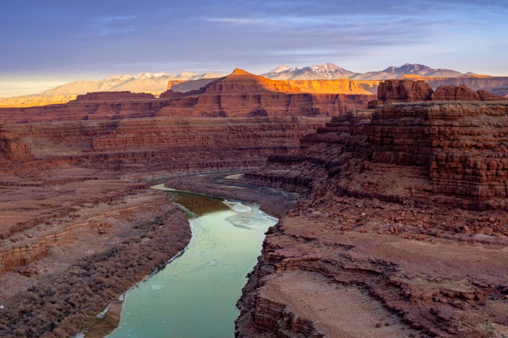 Sunset view of a river running through some mountains in the desert.