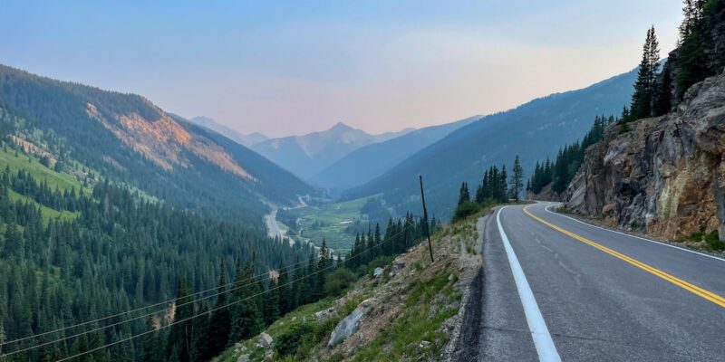The paved road along the Million Dollar Highway which offers stunning views of the mountains and rivers that run through Durango at sunset.