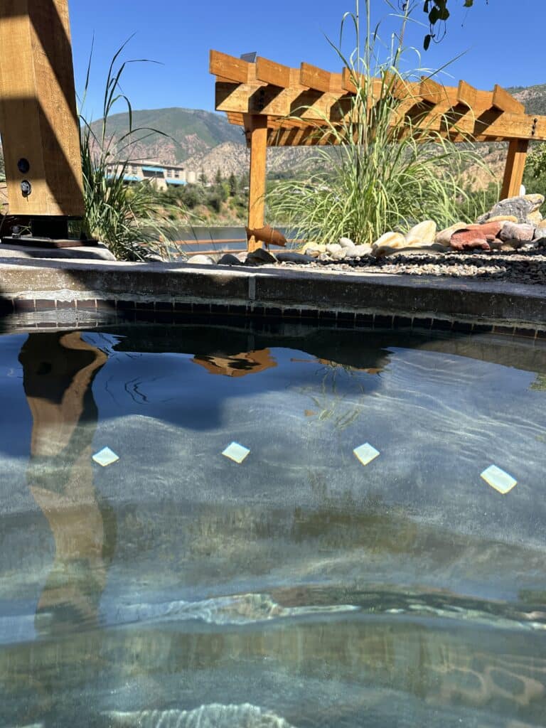 a clear, calm hot springs pool at the iron mountain hot springs in glenwood springs on a clear, sunny day.