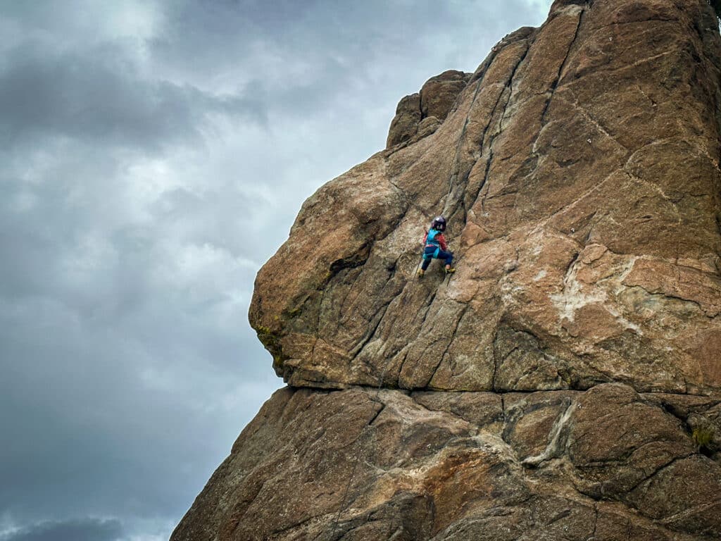 a young child rock climbing on a cloudy day in buena vista colorado