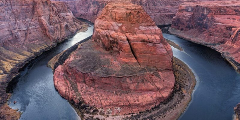 An aerial view of Horsehoe Bend with a cloudy sky in the background.