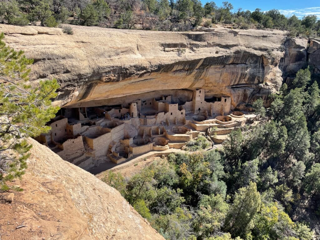 ancestral puebloan cliff dwellings built into a desert hillside.