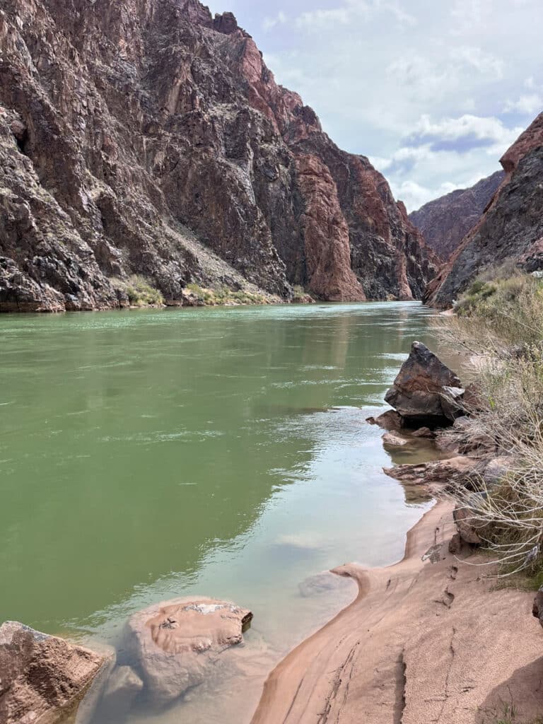 view of the granite gorge. Tall rocky cliffs meet the Colorado river along the old grandview trail