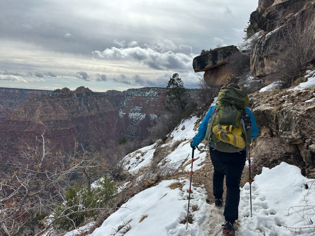 the grandview trail in march with snowy trails, steep drops, and clouds in the sky.
