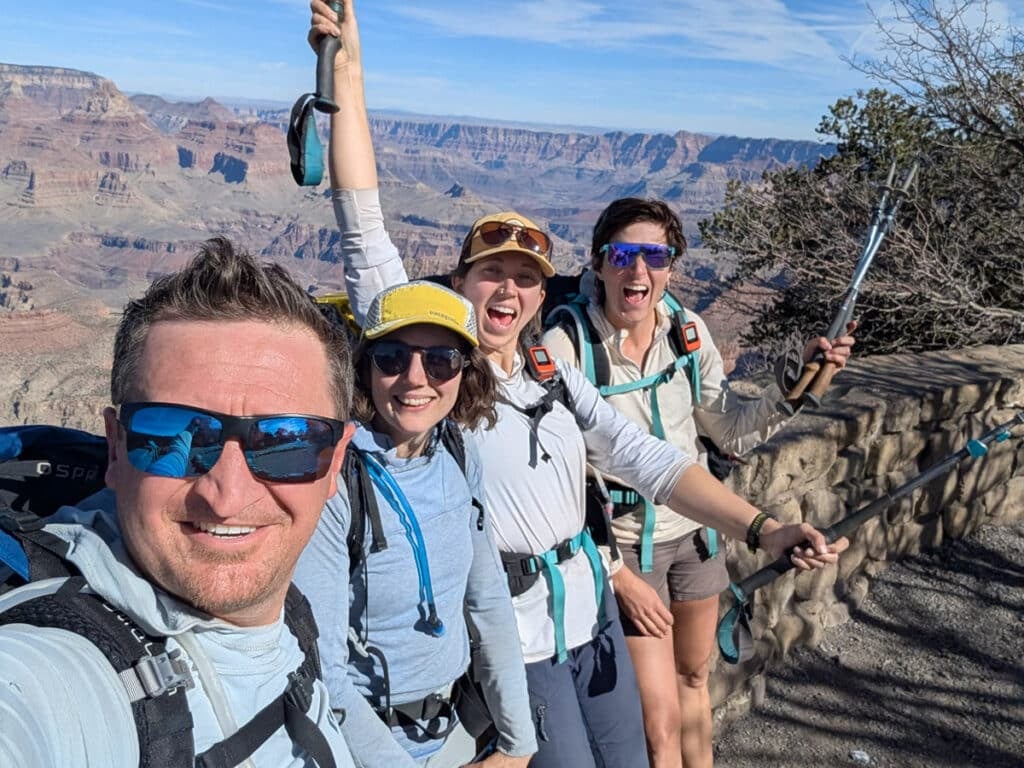 Four people at Grandview point on a sunny day just after finishing the Escalante Route.