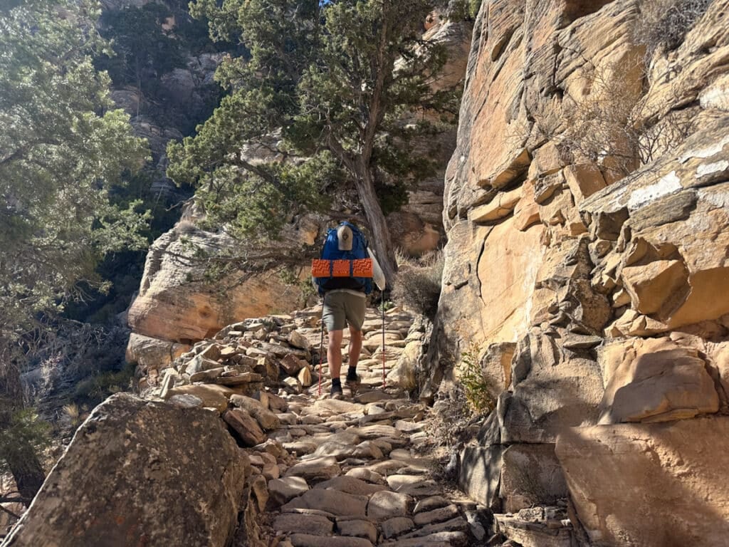 A man walking up the Grandview trail in the shade on a november morning in the Grand CAnyon.