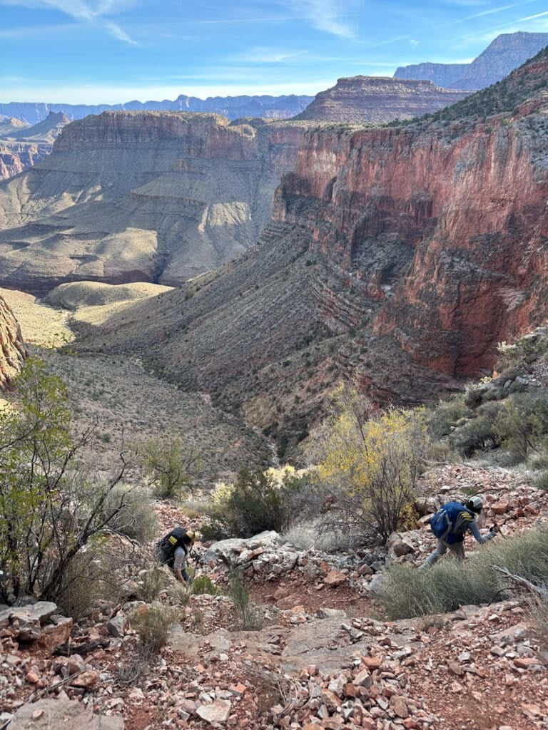 A hiker going through the redwall break, a steep, rocky trail near hance creek in the Grand canyon