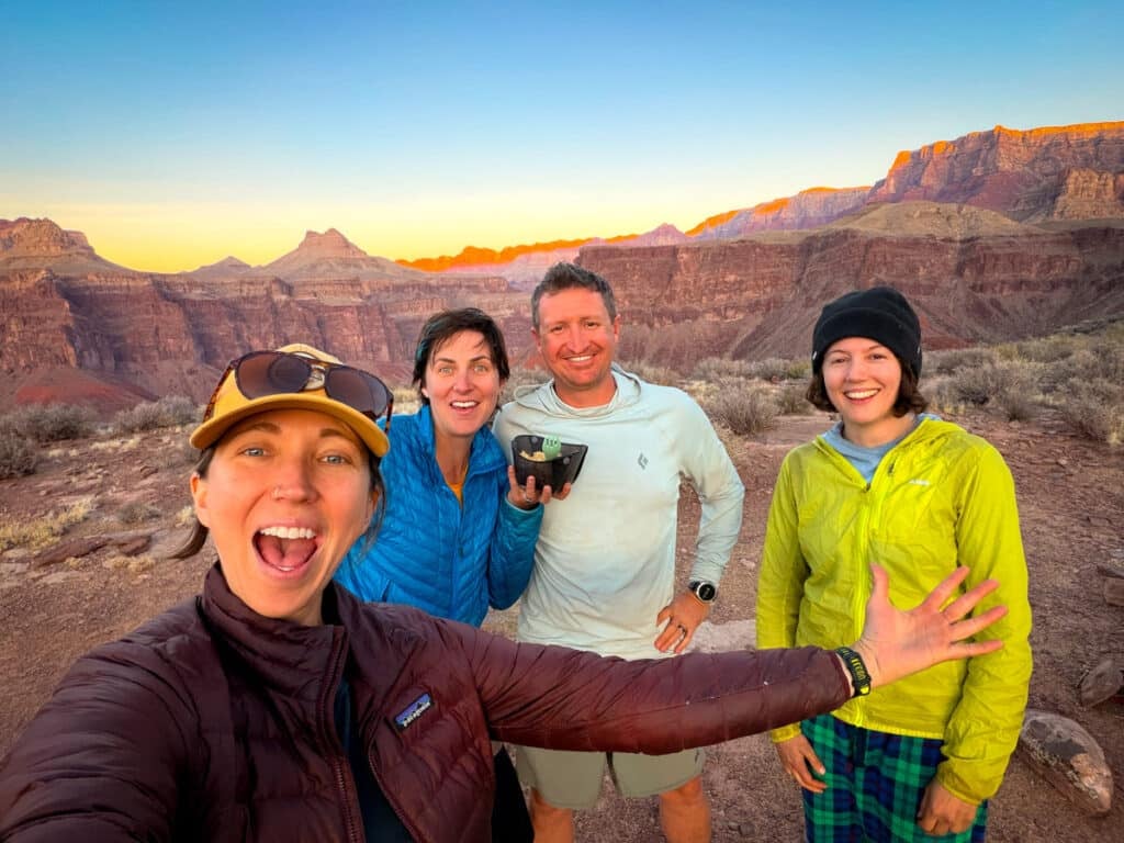 four people eating dinner and watching the sunset in the Grand CAnyon