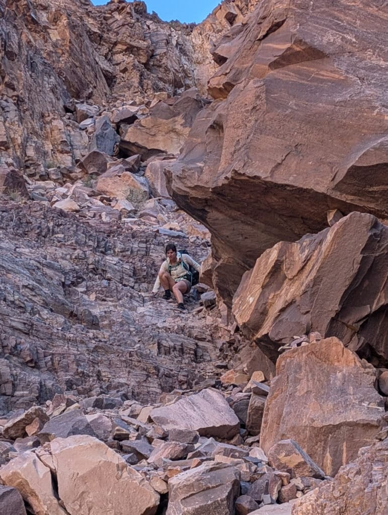 A woman going down the hour glass slide.