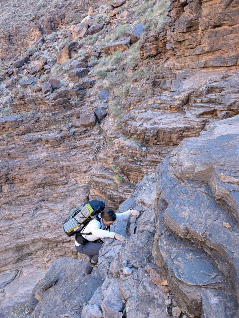 A woman scrambling the papago wall